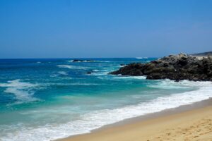 Puerto Escondido sandy beach with turquoise waters and rocky coastline