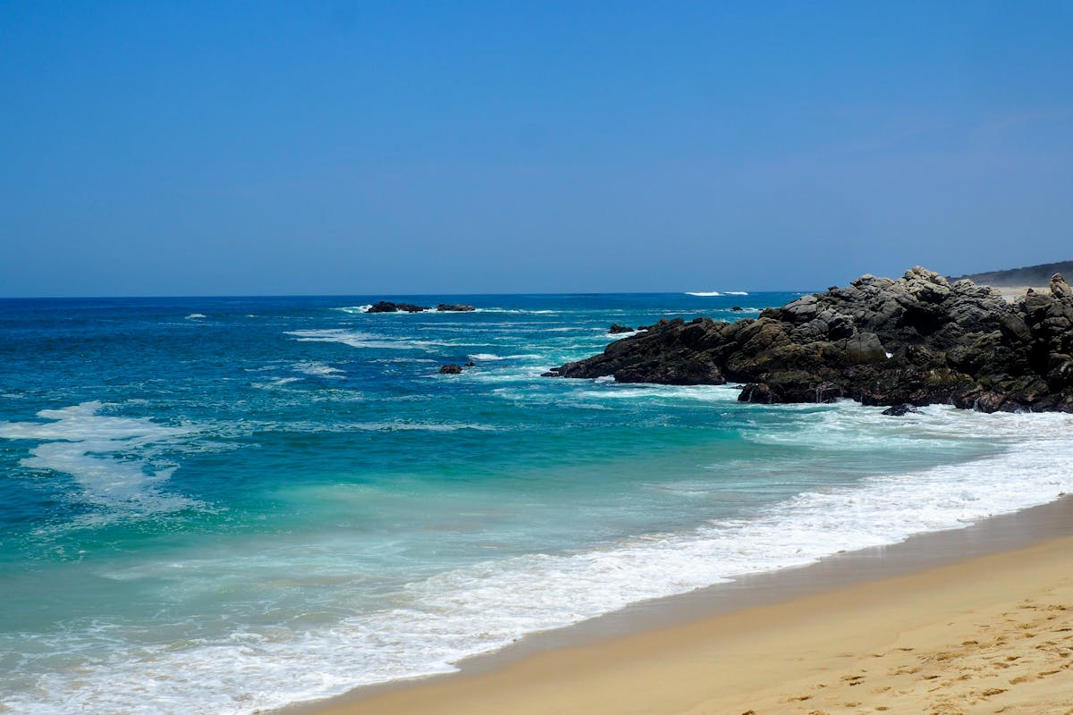Puerto Escondido sandy beach with turquoise waters and rocky coastline