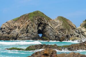 Rock formation with ocean waves at Zipolite Beach Oaxaca Mexico