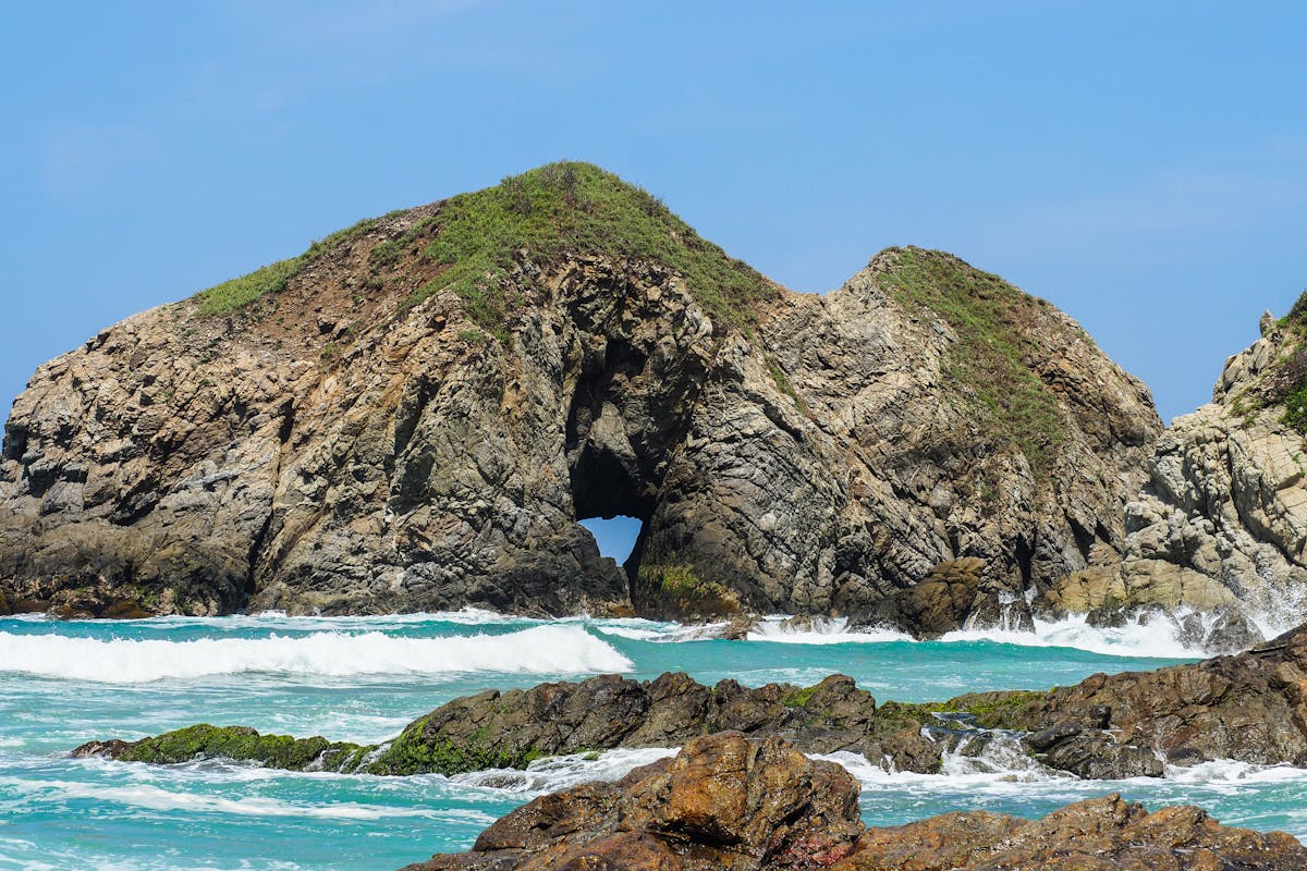 Rock formation with ocean waves at Zipolite Beach Oaxaca Mexico